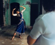 a woman in a blue dress is dancing