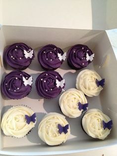 cupcakes with white frosting and purple icing in a box