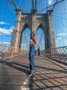 a woman standing in front of the brooklyn bridge