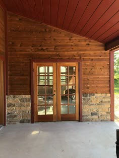 the inside of a wooden building with two doors