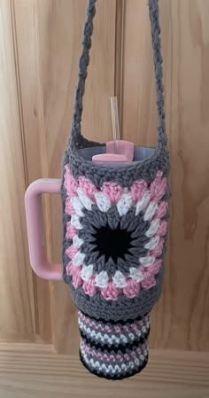 a crocheted coffee cup holder hanging from a hook