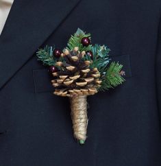 a boutonniere with pine cones, berries and evergreens on it's lapel