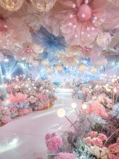 an elaborately decorated event with pink flowers and chandeliers hanging from the ceiling