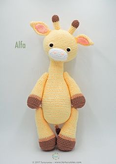 a stuffed giraffe sitting on top of a white wall