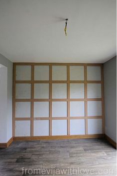 an empty room with white walls and wood paneling