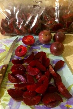 there is a bag of plums next to the sliced plums on the cutting board