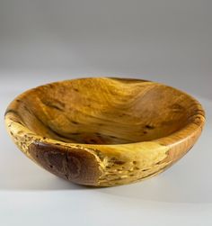 a wooden bowl sitting on top of a white table