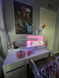 a computer desk with headphones on it and a poster in the background that says wormp womp