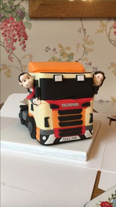 there is a cake made to look like a truck with people riding on the back