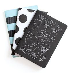 two notebooks sitting next to each other on top of a white table with polka dots