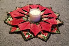 a candle sitting on top of a table next to a red and green ornament