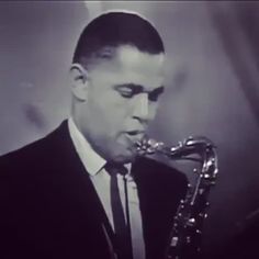 a man in a suit and tie playing a saxophone