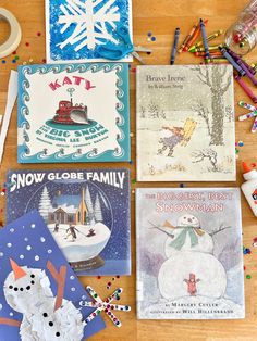 four children's books are laid out on a table with crayons and pencils