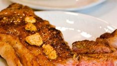 a piece of steak on a white plate