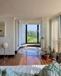 a bedroom with a large window and wooden floors