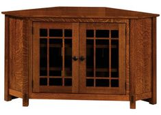 a wooden cabinet with glass doors on the front and bottom shelves, in an oak finish