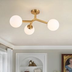 a woman is standing in the middle of a room with three lights on her ceiling