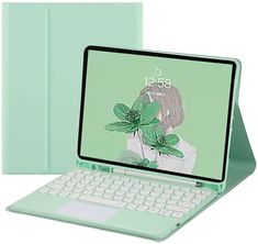 an open laptop computer sitting on top of a white table next to a green cover