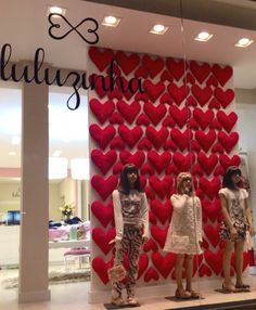 three mannequins are standing in front of a wall with hearts