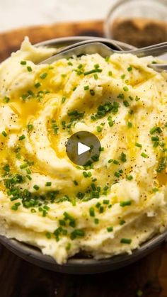 a bowl filled with mashed potatoes on top of a wooden cutting board