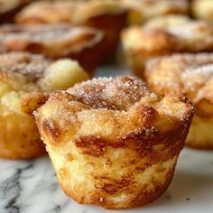 some sugary muffins sitting on top of a marble counter