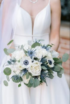 a bridal holding a bouquet of white and blue flowers