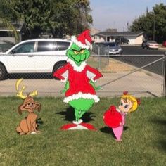 the grinch family is standing in front of their christmas yard decorations on the lawn