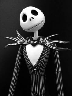 a black and white photo of a jack skellingy doll wearing a striped suit