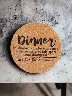 a cork coaster sitting on top of a marble table with the words dinner written on it