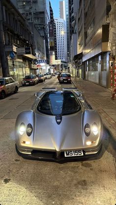 a silver sports car parked on the side of a street