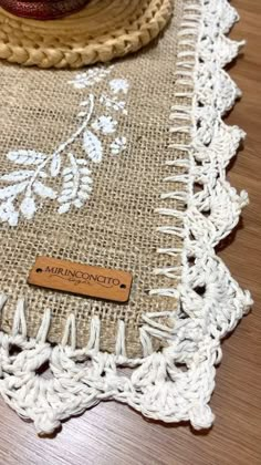 a close up of a doily on a wooden table with a hat and other items