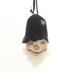 a clown mask hanging from a string with a hat on it's head and nose