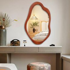 a mirror sitting on top of a dresser next to a bed