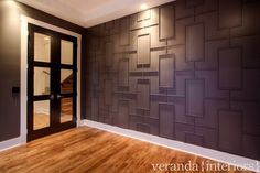 an empty room with wood flooring and a wall made out of squares on it