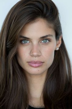 a woman with long brown hair and blue eyes