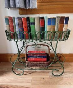 a basket with books sitting on top of it next to a shelf filled with books