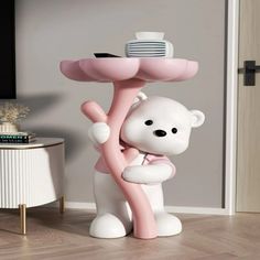 a white bear holding onto a pink object