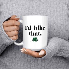 a woman holding a coffee mug with the words i'd hike that on it