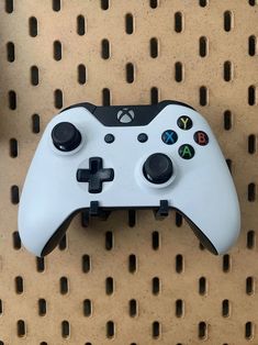 a close up of a controller on a metal surface with holes in the wall behind it