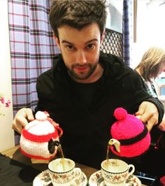 a man is pouring tea into two cups