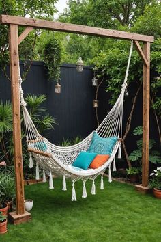 a white hammock with blue and orange pillows hanging from it's sides