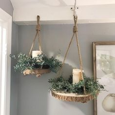 two hanging planters filled with plants and candles