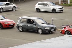 three cars parked in a parking lot next to each other and one person sitting in the driver's seat