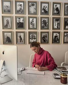 a woman sitting in front of a computer on top of a white desk next to a keyboard and monitor