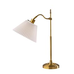 a brass table lamp with a white shade on the base and a gold metal arm