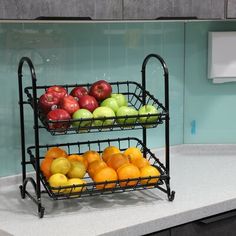 two metal baskets filled with fruit on top of a kitchen counter