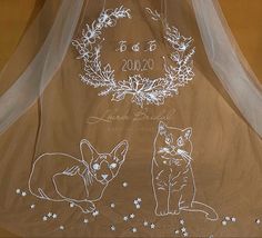 a wedding veil with two cats drawn on it and the bride's name written in white