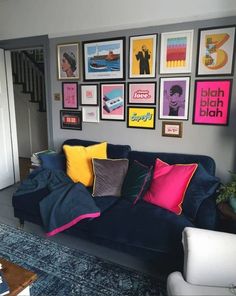 a living room filled with furniture and lots of framed pictures on the wall above it