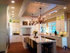 a large kitchen with an island in the middle and lots of lights hanging from the ceiling