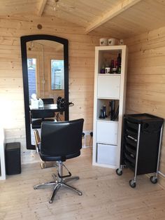 a room with a chair, mirror and other items in the area that is being used as a hair salon